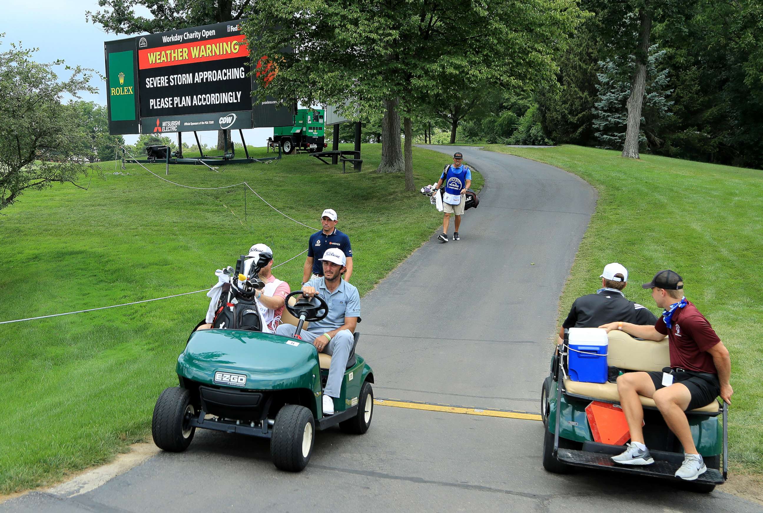 PHOTO: Max Homa and his caddie ride in a cart during a delay due to inclement weather during the second round of the Workday Charity Open on July 10, 2020, at Muirfield Village Golf Club in Dublin, Ohio.