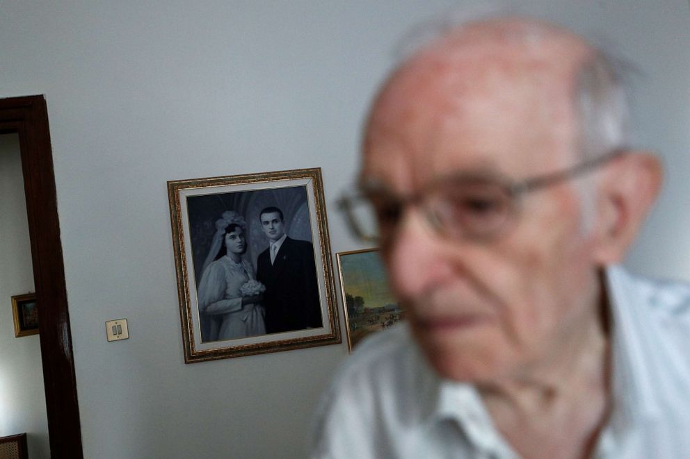 PHOTO: Giuseppe Paterno, 96, Italy's oldest student, walks past a painting hung on the wall depicting his wedding day with his late wife Stefana Battaglia, who died in 2006, and Paterno, two days before he graduates from The University of Palermo.