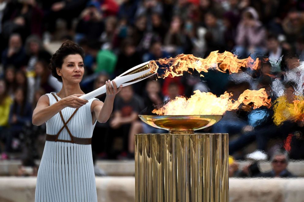 PHOTO: Actress Katerina Lechou, playing a high priestess lights a torch at The Panathenaic Stadium in Athens on October 31, 2017, during the handover ceremony of the Olympic flame for the 2018 Winter Olympics in Pyeongchang, South Korea. 