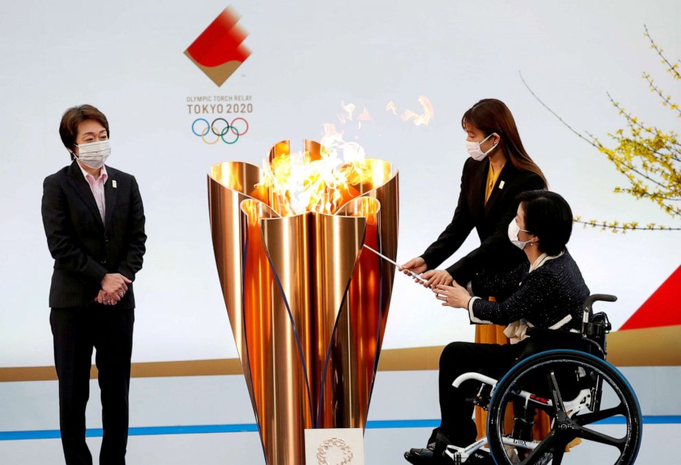 PHOTO: Tokyo 2020 President Seiko Hashimoto looks on as actor Satomi Ishihara and Paralympian Aki Taguchi light the celebration cauldron on the first day of the Tokyo 2020 Olympic torch relay in Naraha, Japan, March 25, 2021.