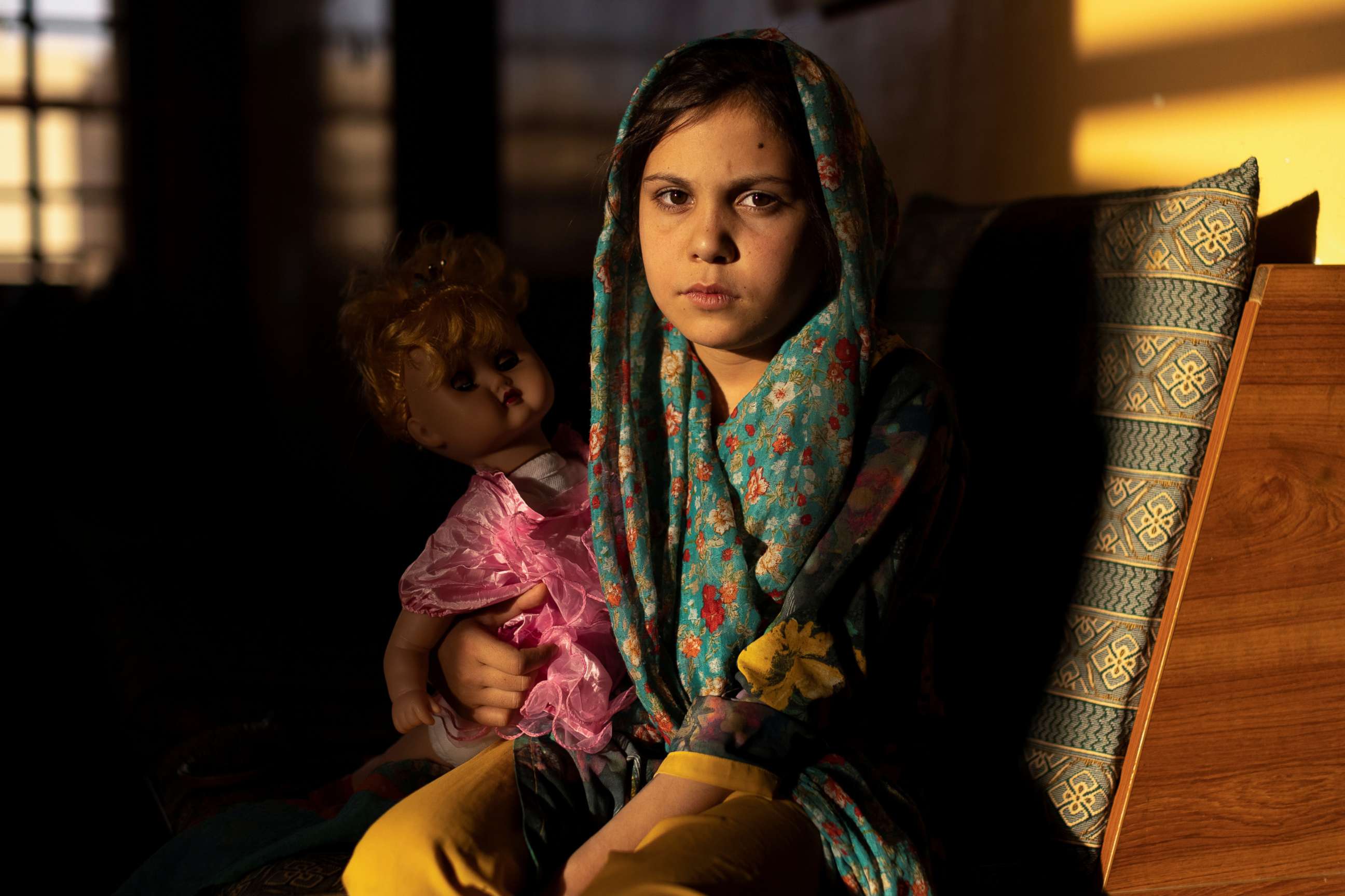 PHOTO: Samira, 9, poses for a photo in the living room at her orphanage, in Kabul, Afghanistan, Oct. 10, 2021. 