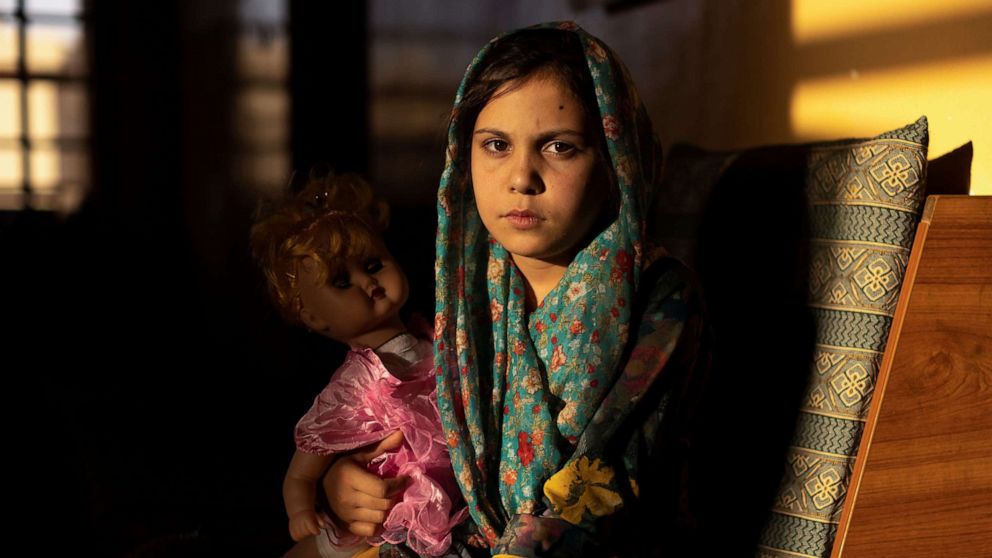 PHOTO: Samira, 9, poses for a photo in the living room at her orphanage, in Kabul, Afghanistan, Oct. 10, 2021. 