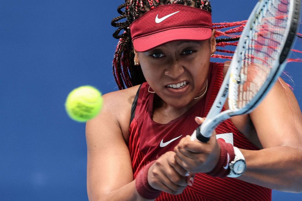 PHOTO: Japan's Naomi Osaka returns a shot to Switzerland's Viktorija Golubic during their Tokyo 2020 Olympic Games women's singles second round tennis match at the Ariake Tennis Park in Tokyo on July 26, 2021.