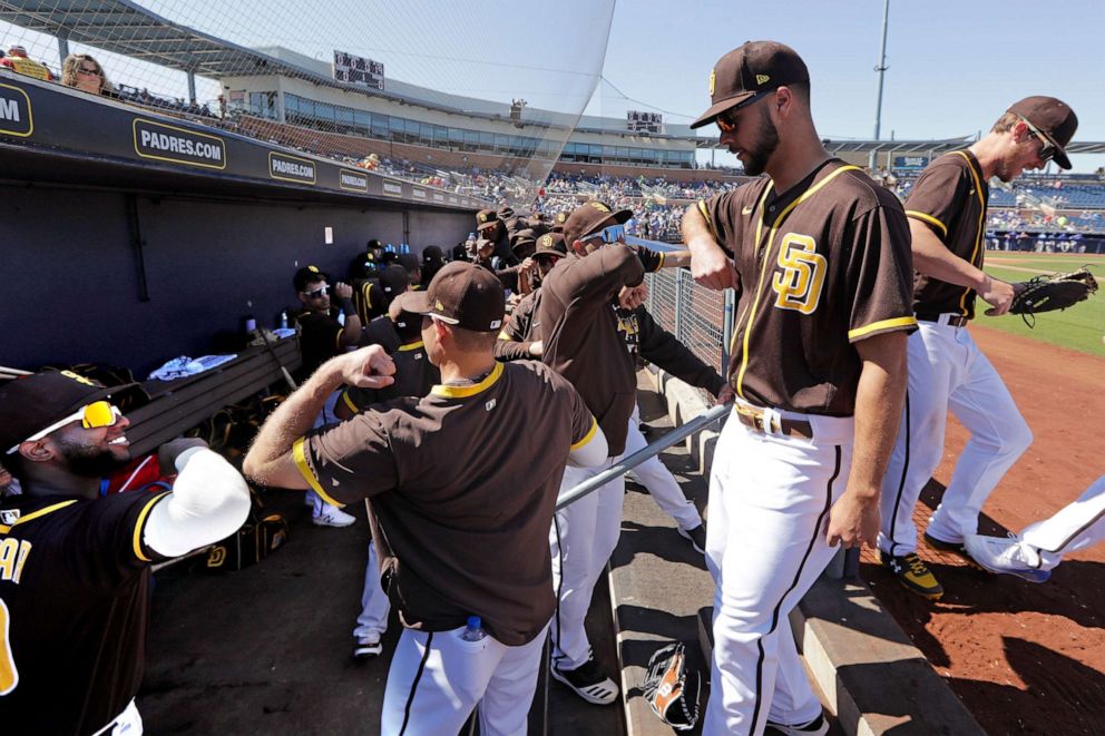 PHOTO: San Diego Padres players bump elbows rather than slap hands while heading into the dugout between innings of a spring training baseball game against the Kansas City Royals, March 4, 2020, in Peoria, Ariz.