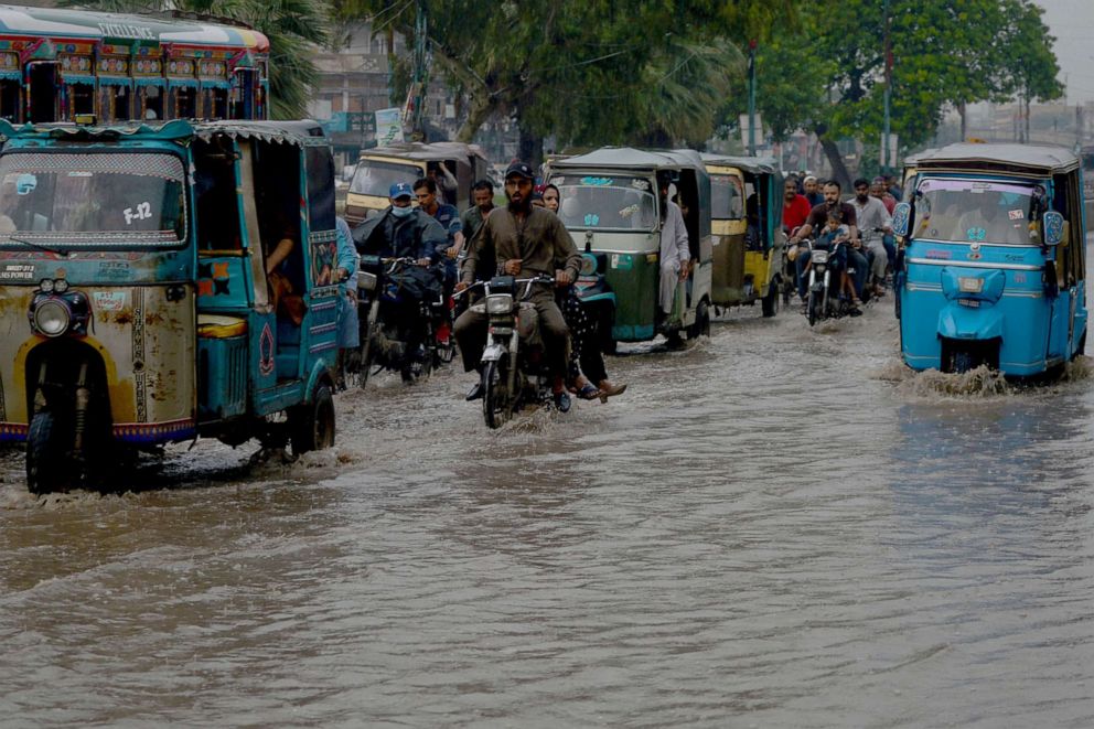 PHOTO: Motorists make their way through a flooded street after heavy rains in Karachi on September 12, 2022. 