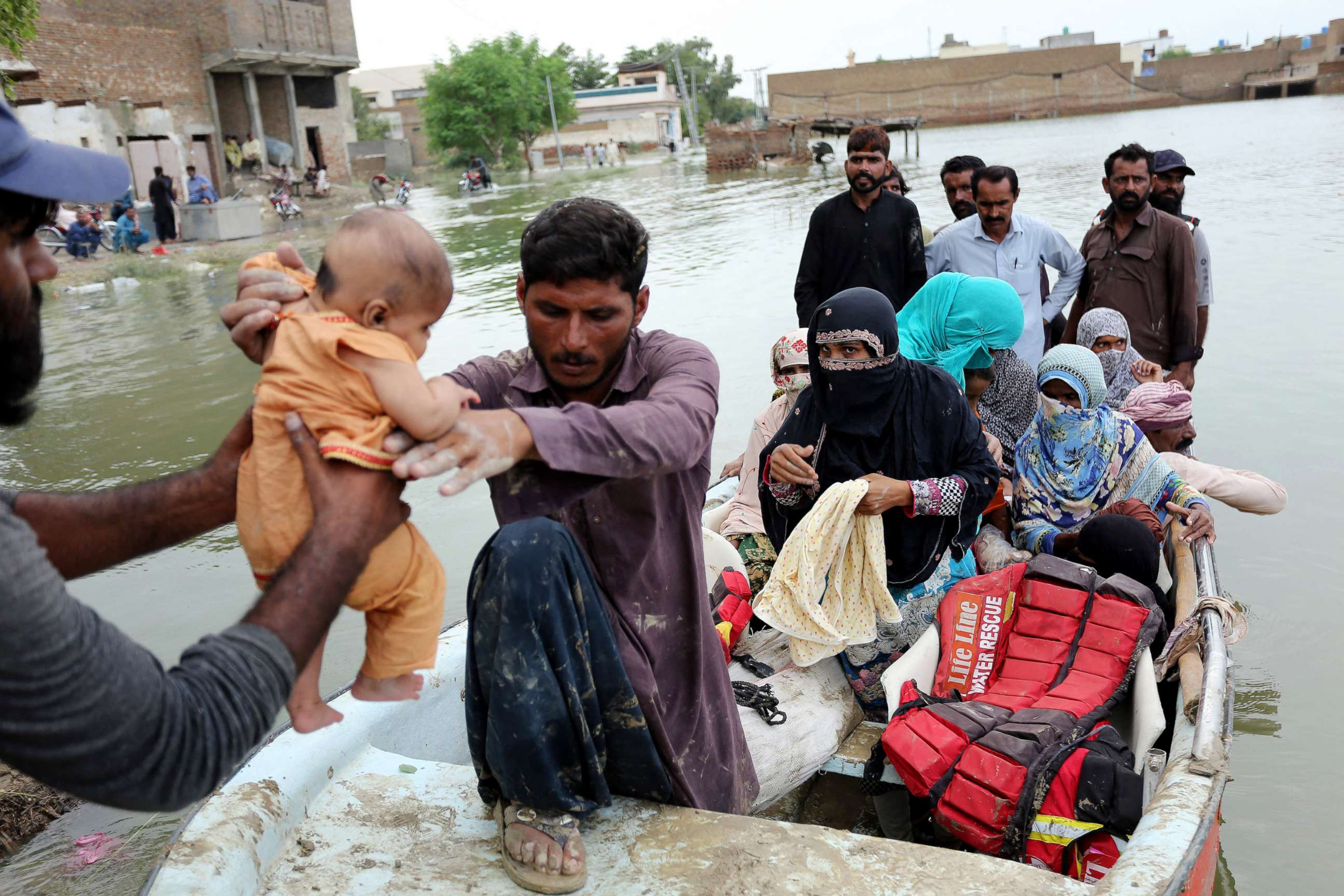 PHOTO: Residents arrive in a boat to a safer place after being evacuated following heavy monsoon rainfall in the flood affected area of Rajanpur district in Punjab province, Aug. 24, 2022. 