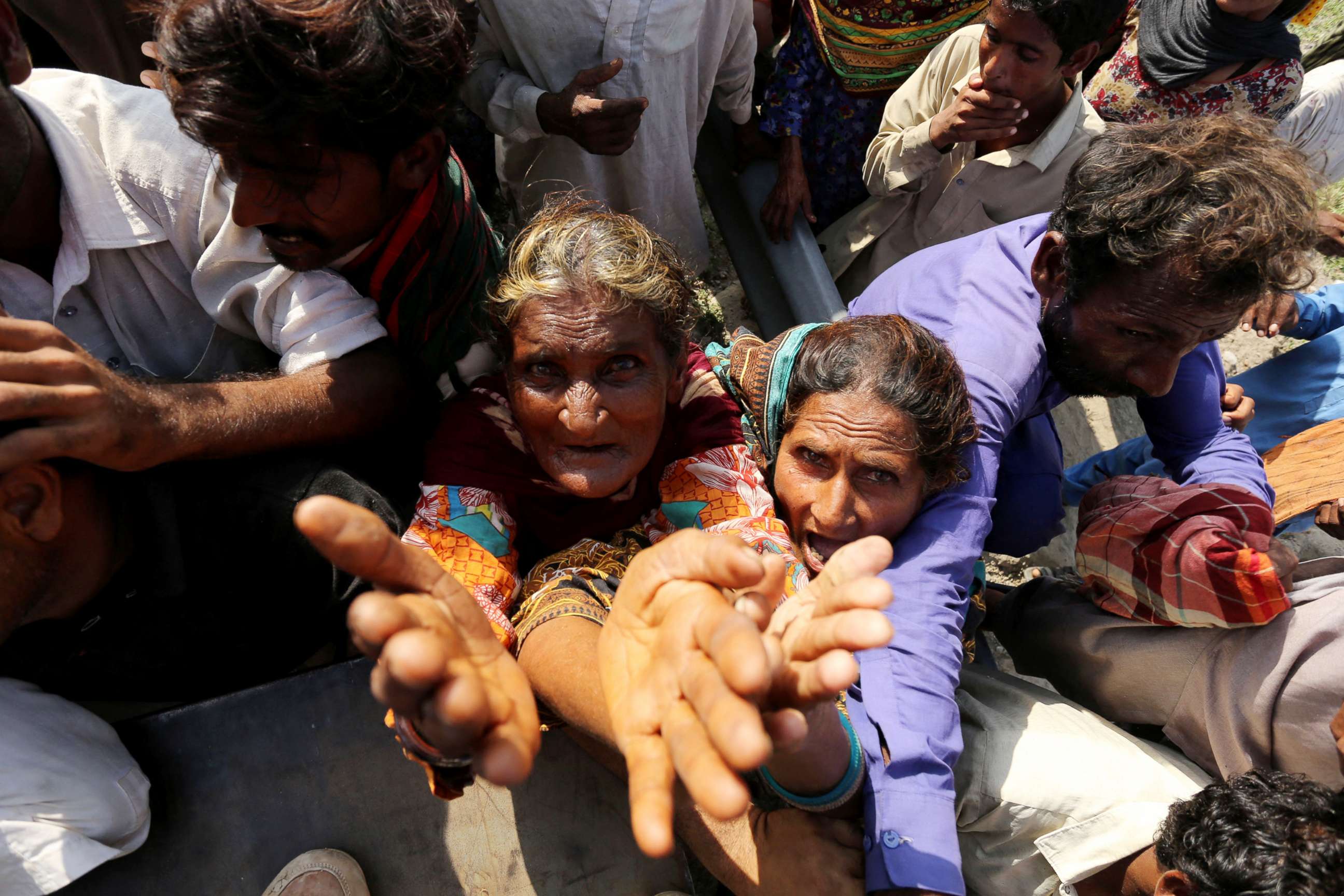 PHOTO: Displaced people wait to receive relief food box in a flood hit area following heavy monsoon rains in Dera Ghazi Khan district of Punjab province, Aug. 29, 2022.