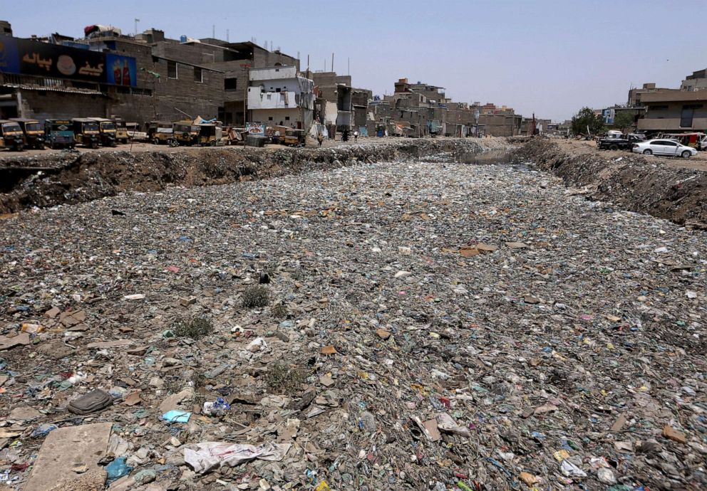 PHOTO: Thick layers of garbage float over a drainage area at a neighborhood in Karachi, Pakistan, April 23, 2021.