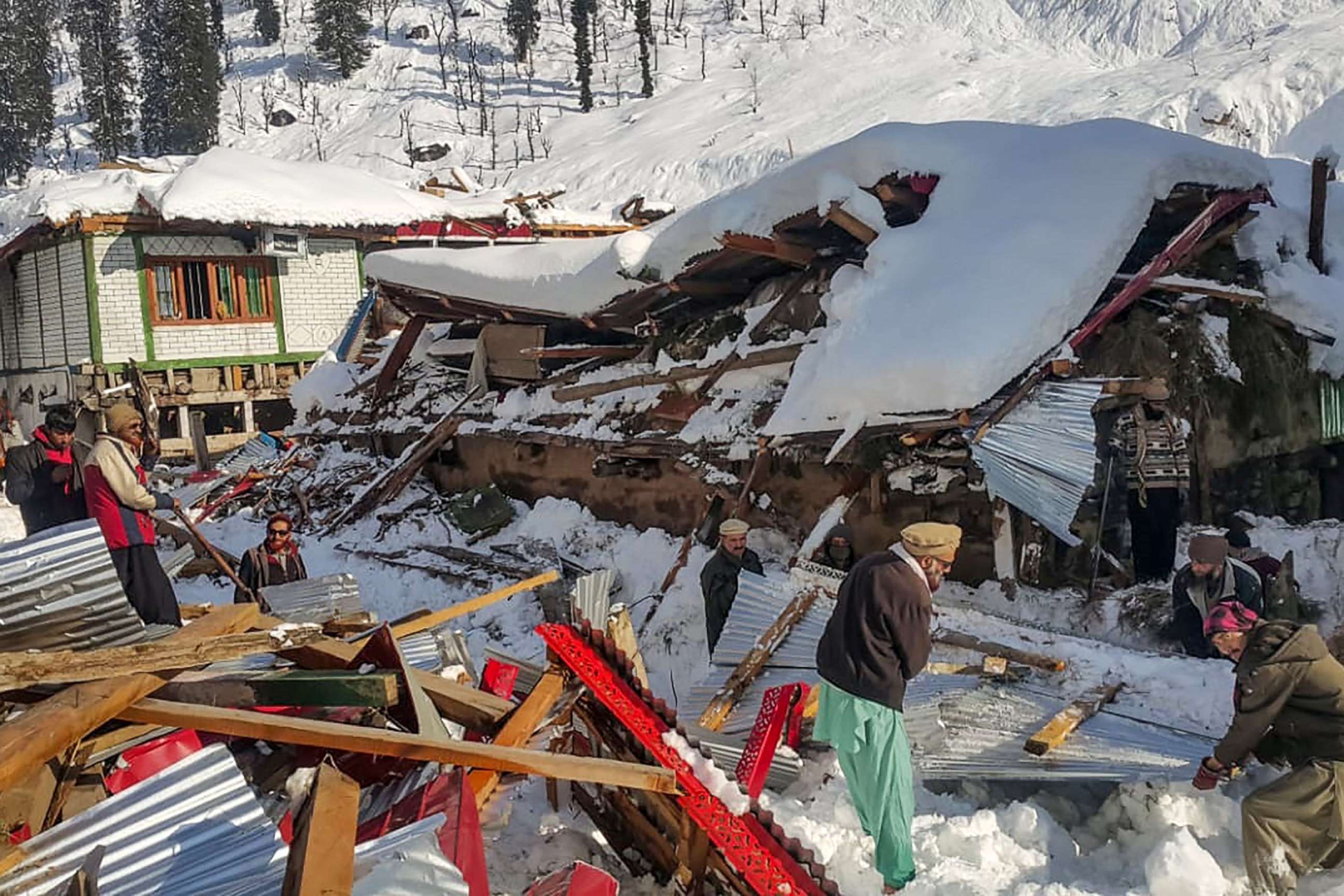 PHOTO: Local residents remove debris of a collapsed house following heavy snowfall that triggered an avalanche in Neelum Valley in the Pakistan-controlled portion of Kashmir on Jan. 14, 2020.