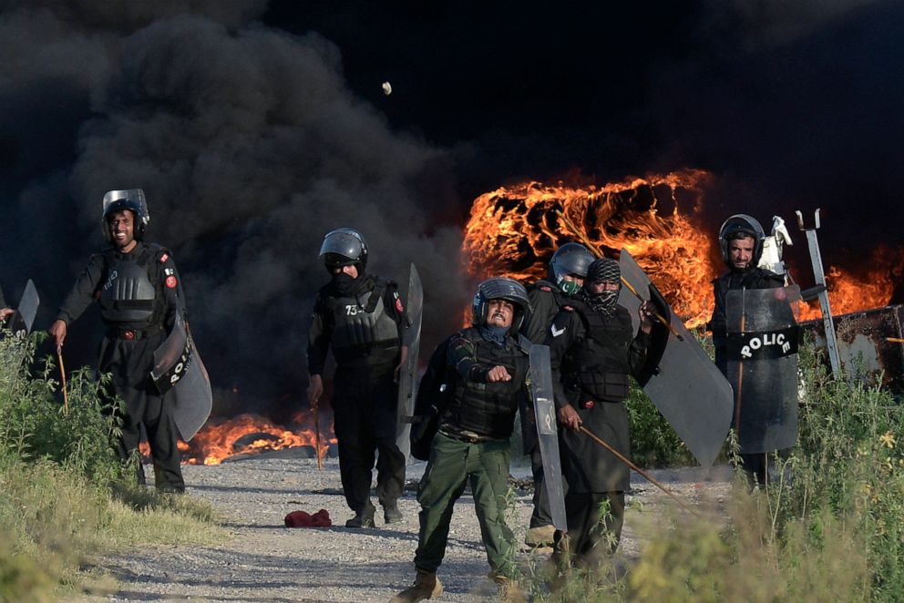 PHOTO: Police officers throw stones towards supporters of Pakistan's former Prime Minister Imran Khan during clashes, in Islamabad, Pakistan, Wednesday, May 10, 2023.