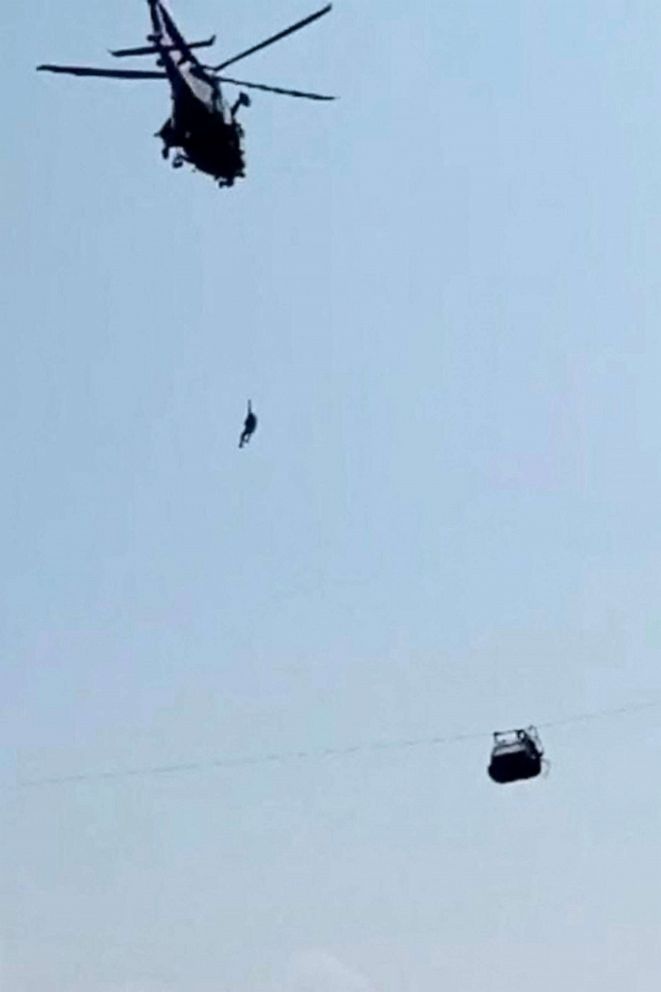 PHOTO: An army soldier slings down from helicopter during a rescue mission to recover students stuck in a chairlift in Pashto village of mountainous Khyber Pakhtunkhwa province, on August 22, 2023.