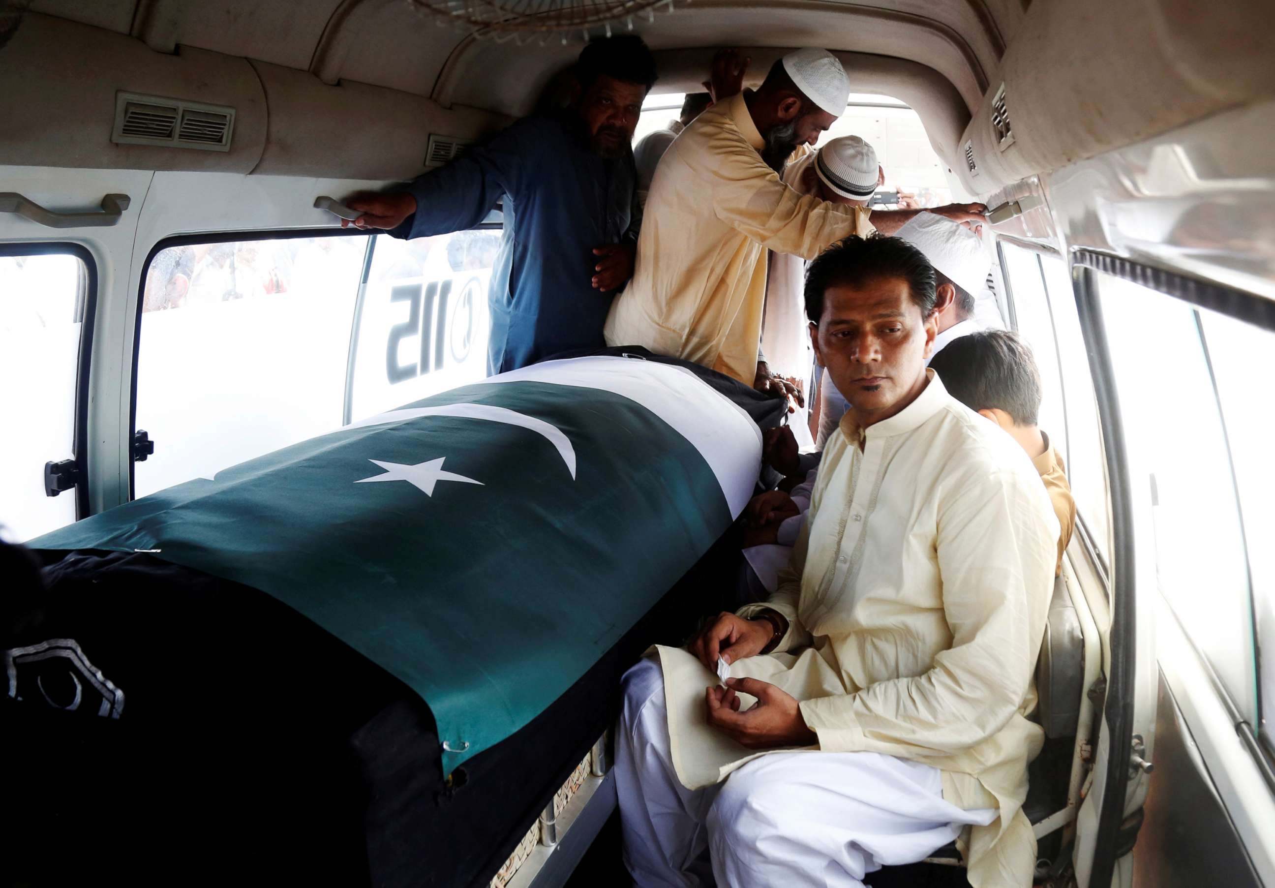 PHOTO: Aziz Sheikh father of Sabika Aziz Sheikh, who was killed when a gunman attacked Santa Fe High School in Santa Fe, Texas, sits in an ambulance next to her coffin, wrapped in national flag, during a funeral in Karachi, Pakistan May 23, 2018.