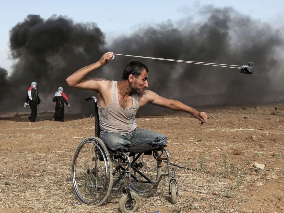 PHOTO: Palestinian Saber al-Ashkar, 29, hurls rocks during clashes with Israeli forces along the border with the Gaza strip, east of Gaza City, May 11, 2018.