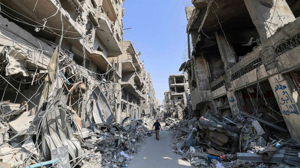 PHOTO: A Palestinian man walks amid the rubble of buildings hit in Israeli air strikes in Khan Yunis in the southern Gaza Strip on October 24, 2023.