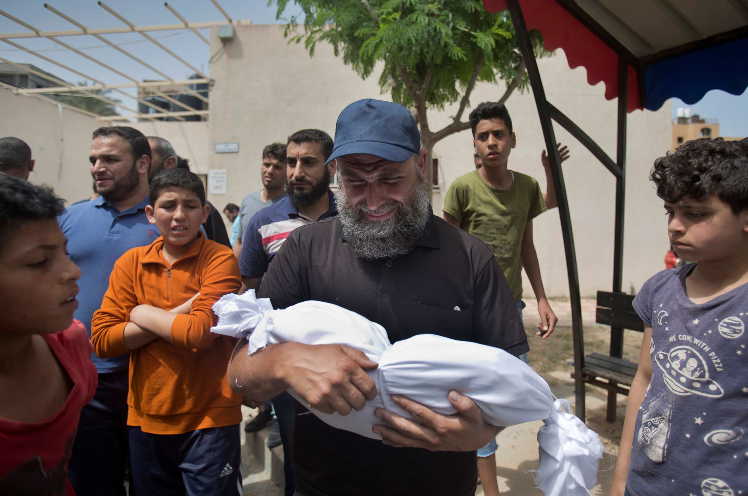 PHOTO:A man cries as he carries the body of a four-month-old Palestinian girl Maria Al-Ghazali, who was killed along with her parents Sunday night by an Israeli missile strike, during her funeral in town of Beit Lahiya, northern Gaza Strip, May. 6, 2019.