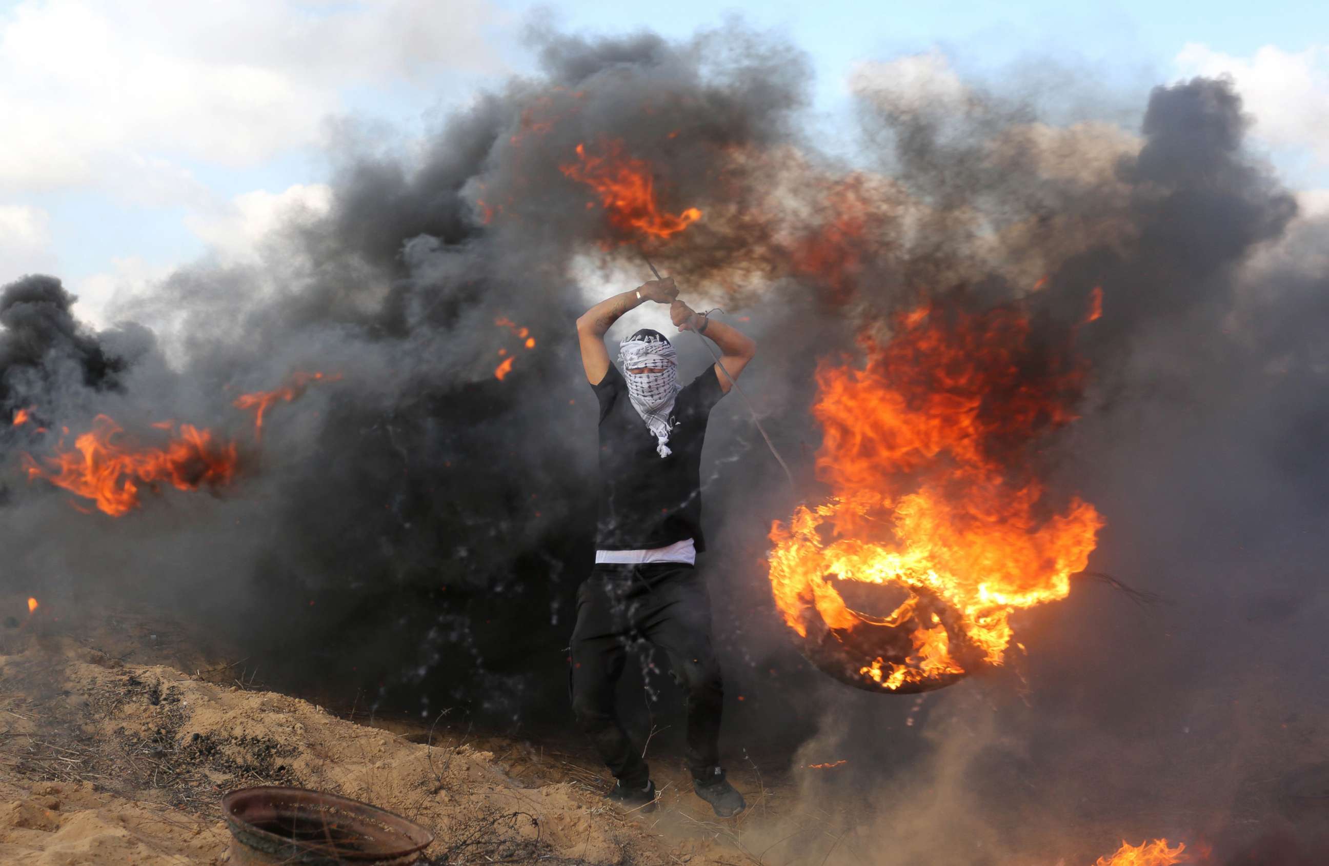PHOTO: Palestinian protesters burn tires in response to Israeli forces' intervention on the 14th week of right of return march along the border with Israel, east of Khan Yunis in the southern Gaza Strip on June 29, 2018.