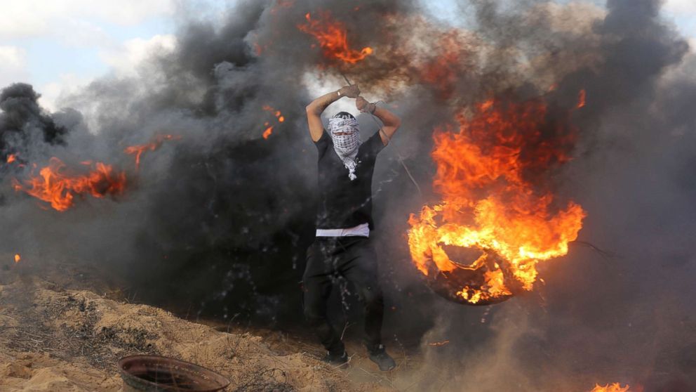 PHOTO: Palestinian protesters burn tires in response to Israeli forces' intervention on the 14th week of right of return march along the border with Israel, east of Khan Yunis in the southern Gaza Strip on June 29, 2018.