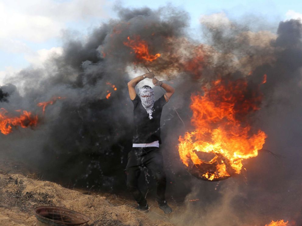 PHOTO: Palestinian protesters burn tires in response to Israeli forces intervention on the 14th week of right of return march along the border with Israel, east of Khan Yunis in the southern Gaza Strip on June 29, 2018.