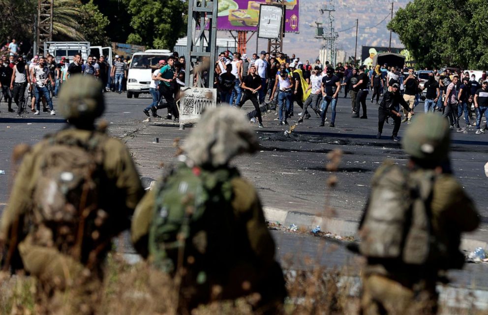 PHOTO: Palestinian protesters clash with Israeli security forces at the Hawara checkpoint south of Nablus city, in the occupied West Bank, on May 18, 2021.