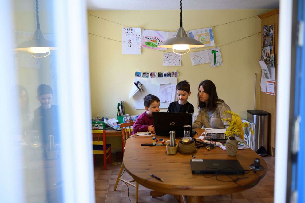 PHOTO: Leo and Espen are assisted by their mother Moira as they navigate online learning resources provided by their infant school in the village of Marsden, near Huddersfield, northern England on March 23, 2020.