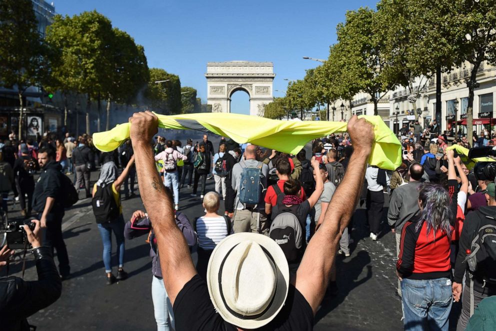 PHOTO: A man holds up a yellow vest in front of the Arc de Triomphe on the Champs Elysees avenue during an anti-government demonstration called by the "yellow vest" (gilets jaunes) movement, on September 21, 2019 in Paris.