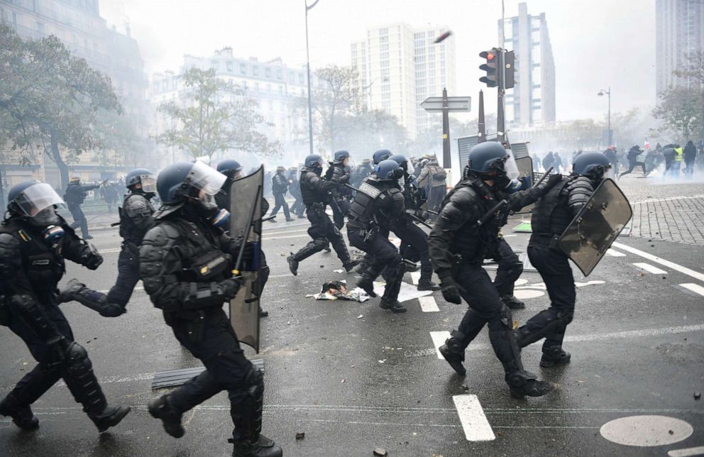 PHOTO: Riot mobile gendarmes run on place d'Italie in Paris on November 16, 2019, during a demonstration of the "yellow vest" (gilets jaunes) marking the first anniversary of the movement.
