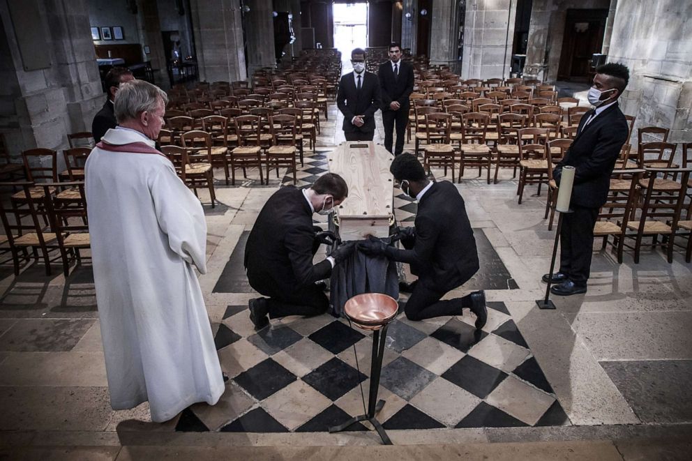 PHOTO: Undertaker employees carry the coffin of a victim of COVID-19 at the Saint Medard Church, in Paris, April 27, 2020. 
