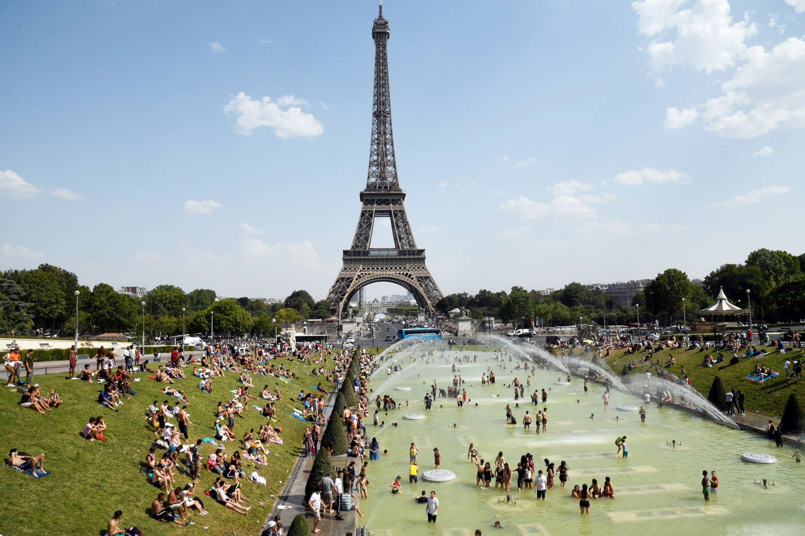 PHOTO:People cool off and sunbathe by the Trocadero Fountains next to the Eiffel Tower in Paris, on July 25, 2019 as a new heatwave hits the French capital.