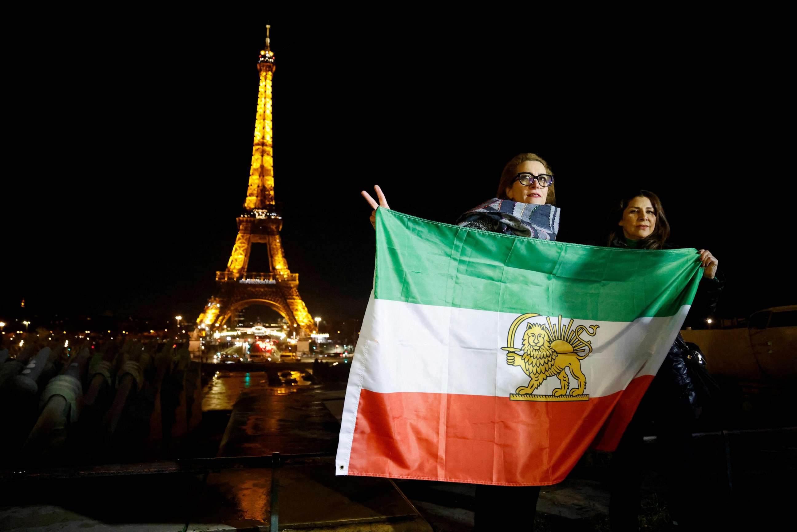 PHOTO: Protesters hold Iran's former flag on the Trocadero Esplanade Trocadero Esplanade during an event to display the slogan "Woman. Life. Freedom." on the Eiffel Tower, in a show of support to the Iranian people, in Paris, on Jan. 16, 2023.