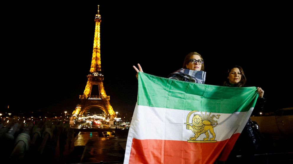 写真: トロカデロ・エスプラネード・トロカデロ・エスプラネードで、スローガンを表示するイベント中にイランの旧旗を掲げる抗議者たち "女性。 人生。 フリーダム。" 2023 年 1 月 16 日、パリのエッフェル塔で、イラン国民への支持を表明。