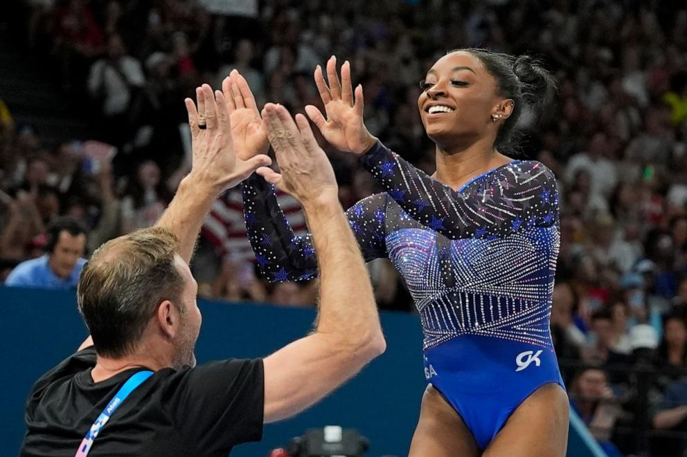 PHOTO: Simone Biles of the U.S. slaps hands with her coach Laurent Landi after performing on the vault during the artistic gymnastics women's all-around final at the 2024 Paris Olympics, Aug. 1, 2024.