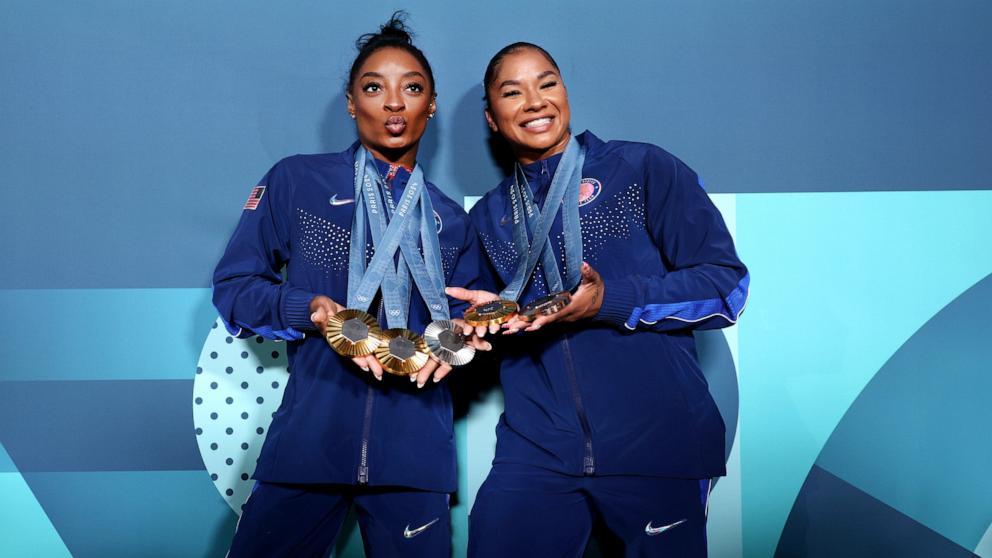 PHOTO: Gymnast Simone Biles of the U.S. displays her three gold medals and silver medal while Jordan Chiles displays her gold and bronze medals won during the women's artistic gymnastics competition at the 2024 Paris Olympics, Aug 5, 2024.