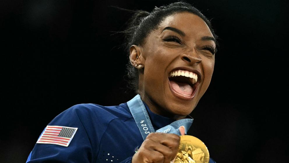 PHOTO: Simone Biles poses with the gold medal after the U.S. won the artistic gymnastics women's team final at the 2024 Paris Olympics, July 30, 2024.