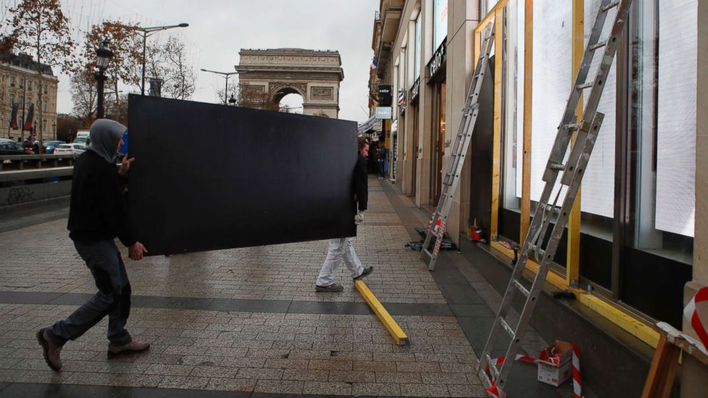 PHOTO: Workers carry a wooden piece to protect shop windows on the Champs-Elysees avenue, Friday, Dec. 7, 2018 in Paris.