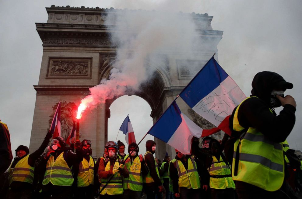 PHOTO: Protesters wearing yellow vests wave flares and French flags near the Arc de Triomphe during a demonstration over high fuel prices on the Champs Elysee in Paris, Dec. 1, 2018.