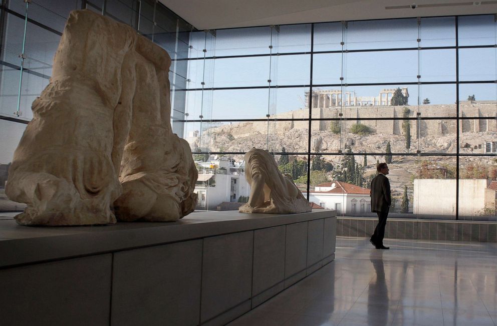 PHOTO: Visitors to Athens' Acropolis Museum look at the frieze of the Temple of Parthenon, Oct. 14, 2014, in Athens, Greece, as the Parthenon sits on top of the mountain in the distance.