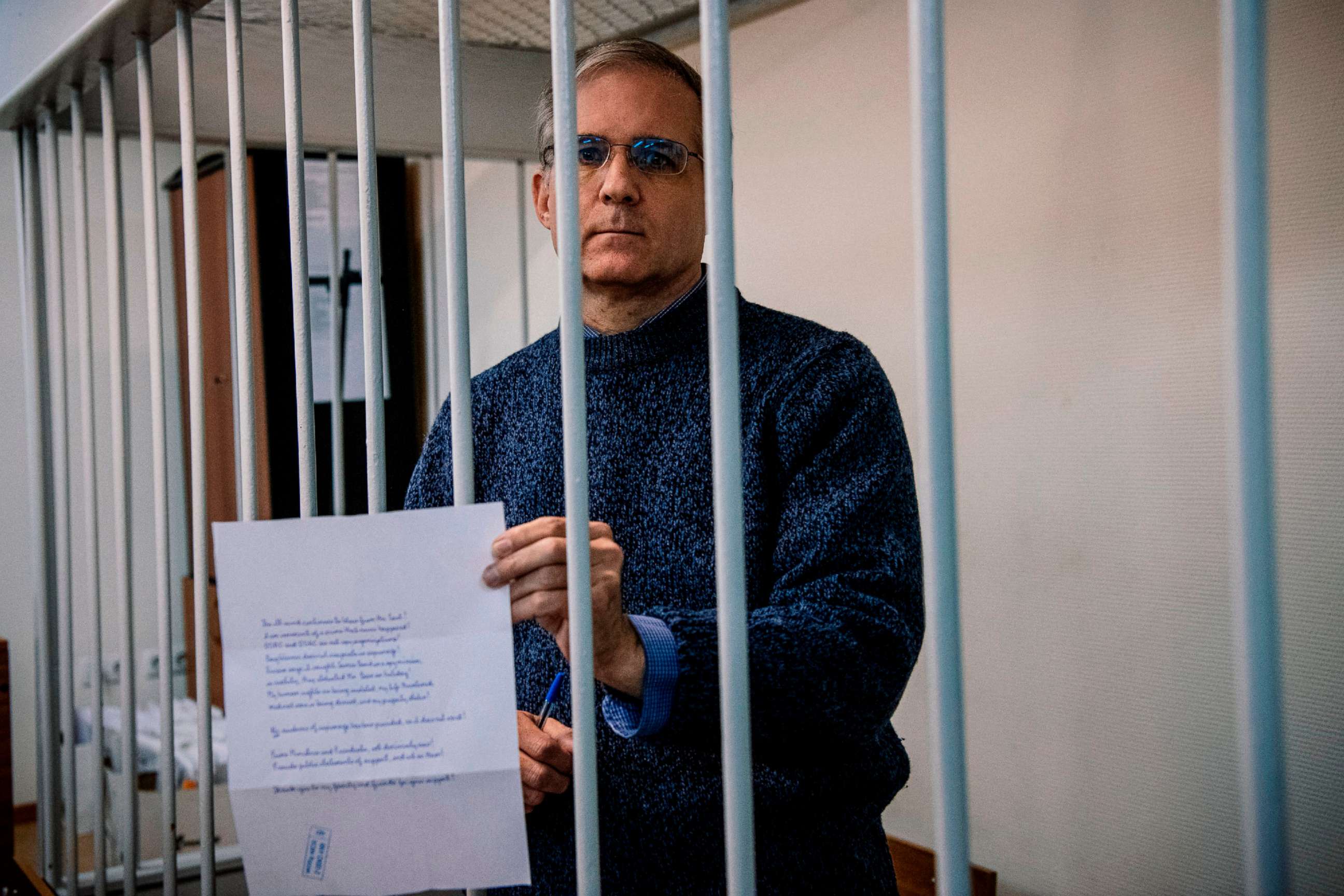PHOTO: Paul Whelan, a former U.S. Marine accused of espionage and arrested in Russia in Dec. 2018, holds a message as he stands inside a defendants' cage before a hearing to decide to extend his detention at the Lefortovo Court in Moscow on Oct. 24, 2019.