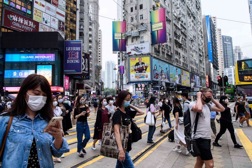 PHOTO: Pedestrians wear face masks as a precautionary measure against the novel coronavirus as they walk across a road in Hong Kong on May 13, 2020.