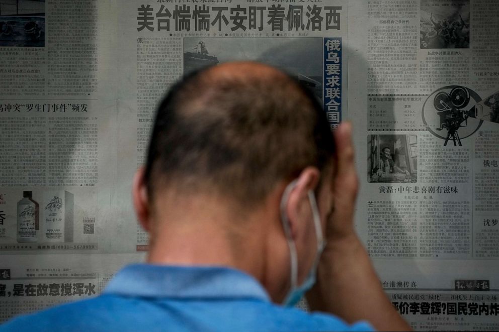 PHOTO: A man rubs his forehead as he reads a newspaper headline reporting "U.S. Taiwan staring anxiously on U.S. House Speaker Nancy Pelosi" at a stand in Beijing, China, on Aug. 2, 2022.
