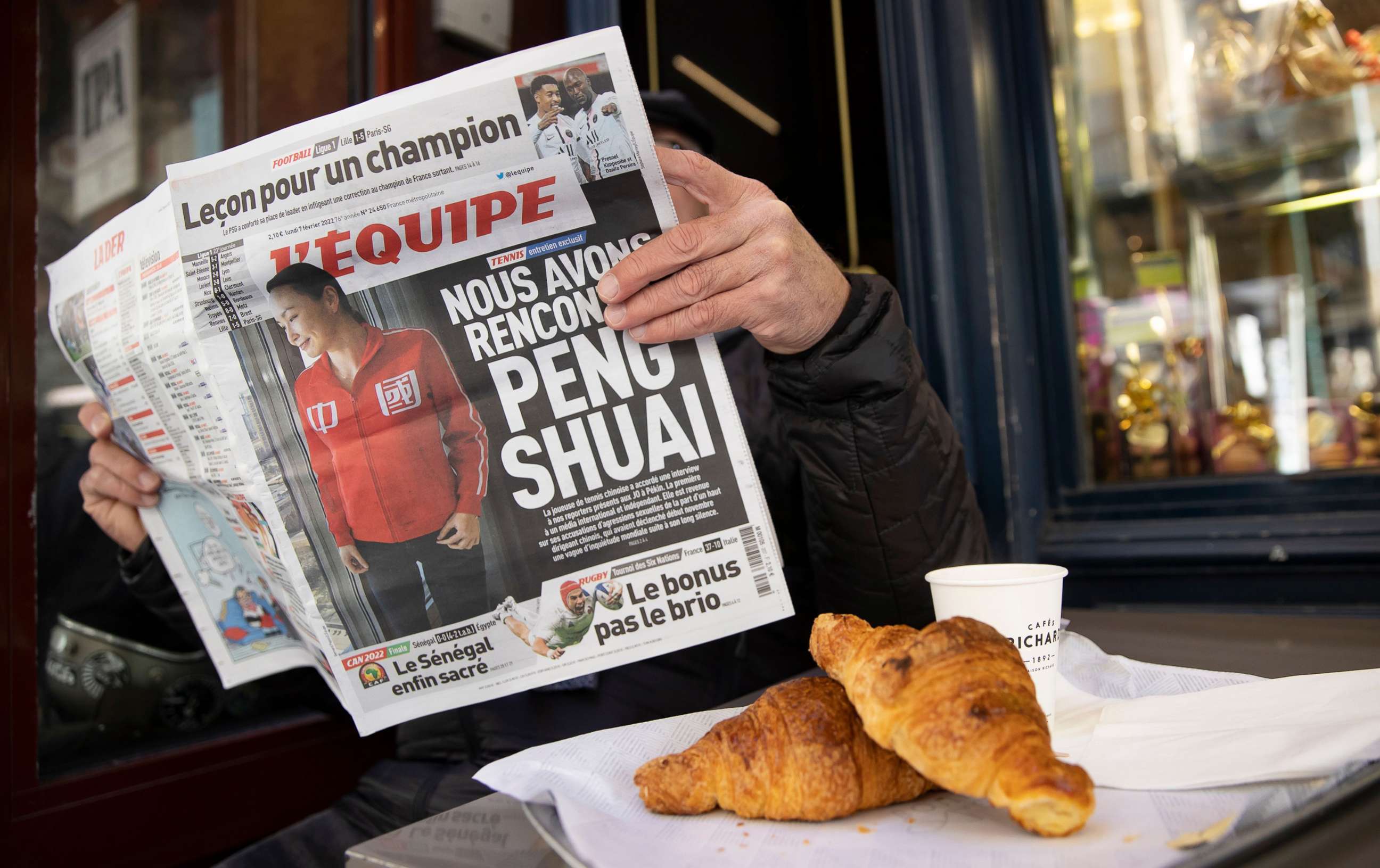 PHOTO: A man reads the French daily sports newspaper L'Equipe with Chinese tennis player Peng Shuai on the cover in Paris, France, Feb. 7, 2022.