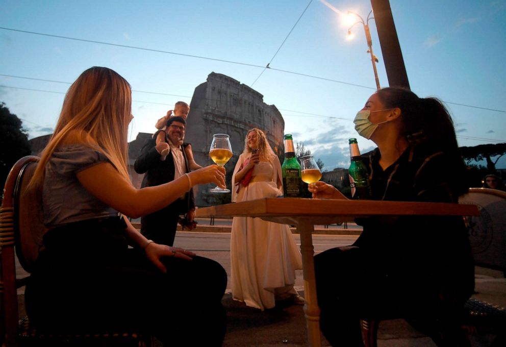 PHOTO: People gather for an aperitif drink outside a bar by the Colosseum in Rome, Italy, on May 18, 2020, as the nationwide lockdown is eased after over two months of measures aimed at curbing the spread of the novel coronavirus.