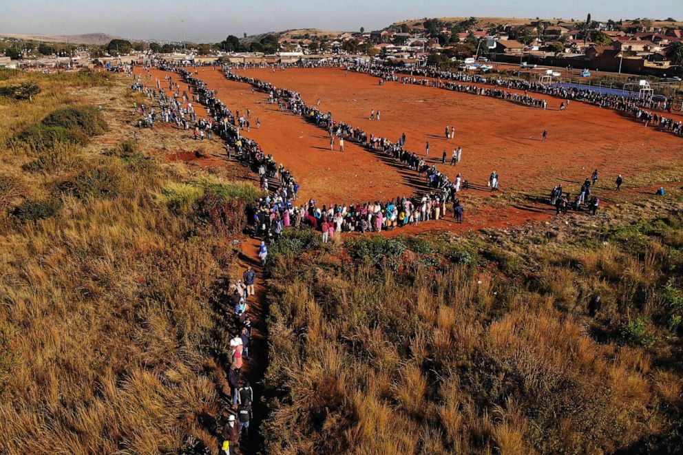 PHOTO: This aerial view shows people queueing during a distribution of hampers, masks, soap and sanitizer organized by different charities at the Iterileng informal settlement near Laudium suburb in Pretoria, South Africa, on May 20, 2020.