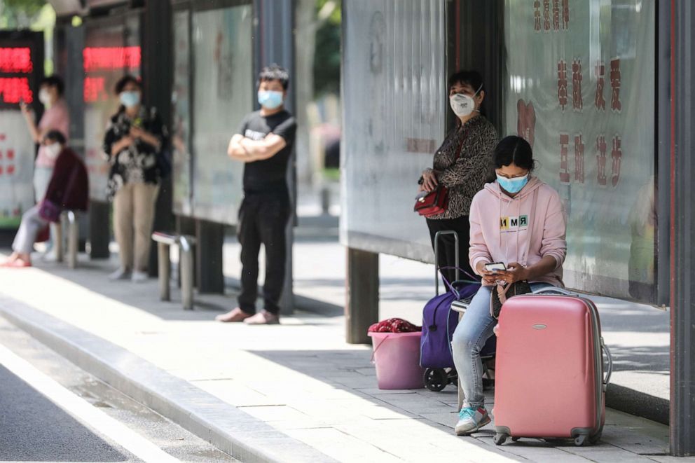 PHOTO: People wait at a bus station in Wuhan in China's central Hubei province on May 11, 2020.