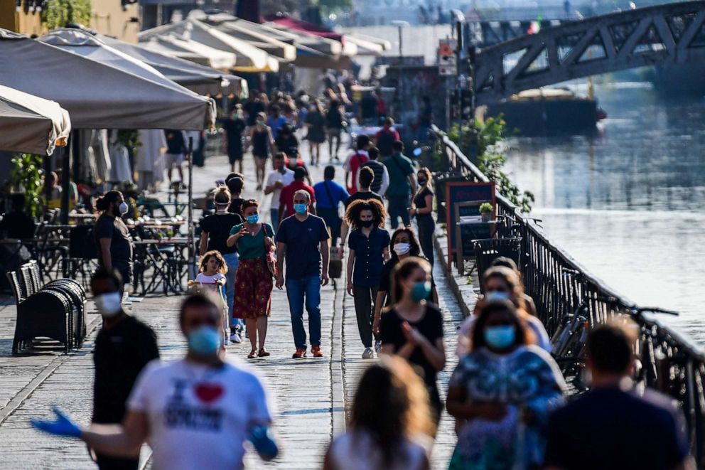 PHOTO: People stroll along a canal in the Navigli district of Milan, Italy, on May 21, 2020, as the country eases a monthslong lockdown aimed at curbing the spread of the novel coronavirus.