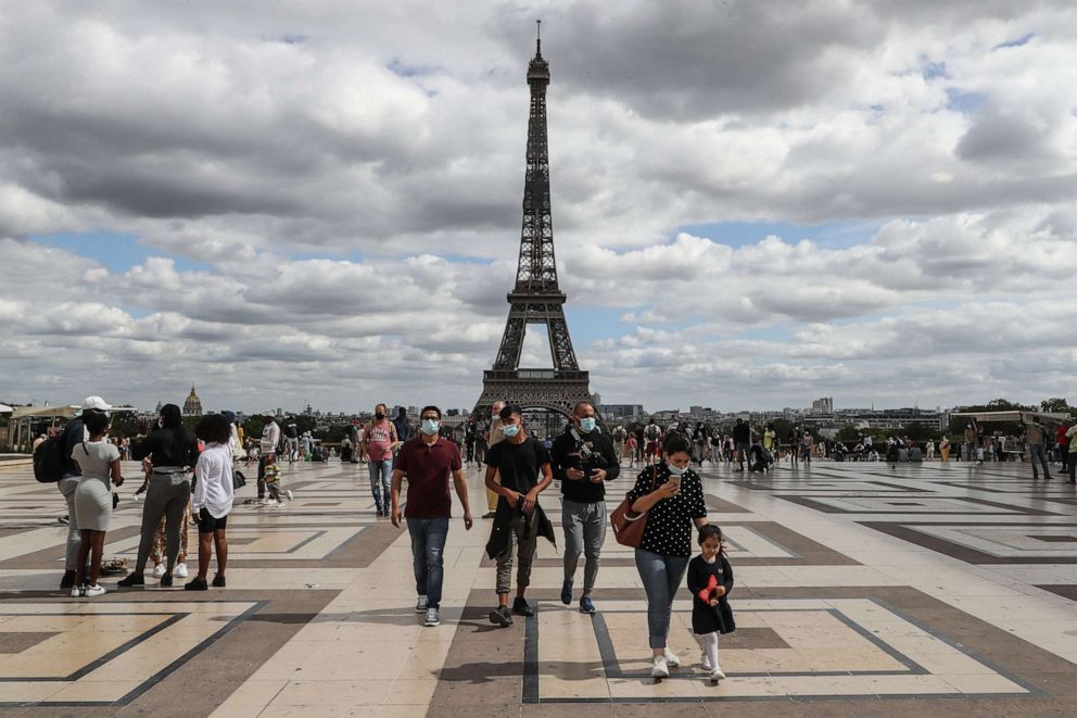 PHOTO: People wearing face masks walk on the Trocadero esplanade, near the Eiffel Tower, in Paris, France, on Aug. 24, 2020.