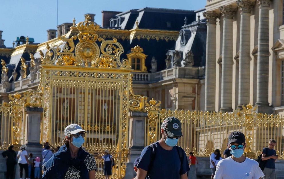 PHOTO: People wearing face masks to prevent against the spread of COVID-19 walk past the Gate of Honor at the Palace of Versailles near Paris, France, on Aug. 4, 2020.