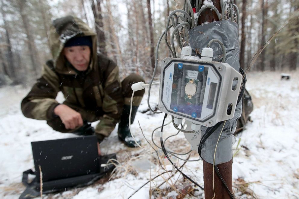 PHOTO: Pavel Konstantinov takes readings from automated temperature data loggers near the village of Chyuya in Russia, Oct. 1, 2021.