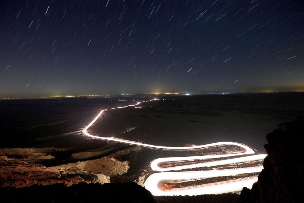 PHOTO: Cars drive through Ramon Crater during the Perseid meteor shower near the town of Mitzpe Ramon, southern Israel, Aug. 12, 2018.