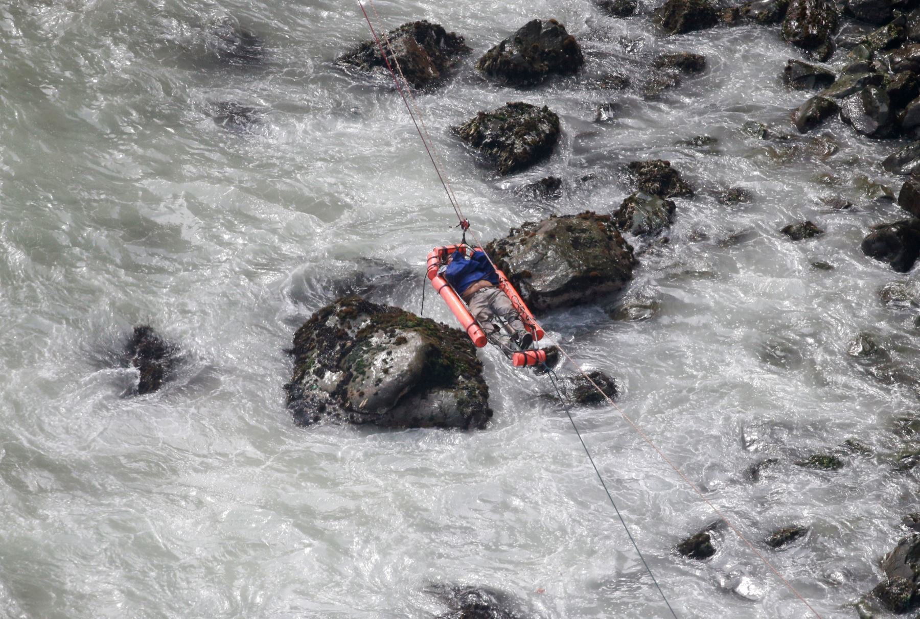 PHOTO: An injured man is transported over water from a bus that fell off a cliff after it was hit by a tractor-trailer rig, in Pasamayo, Peru, Jan. 2, 2018.