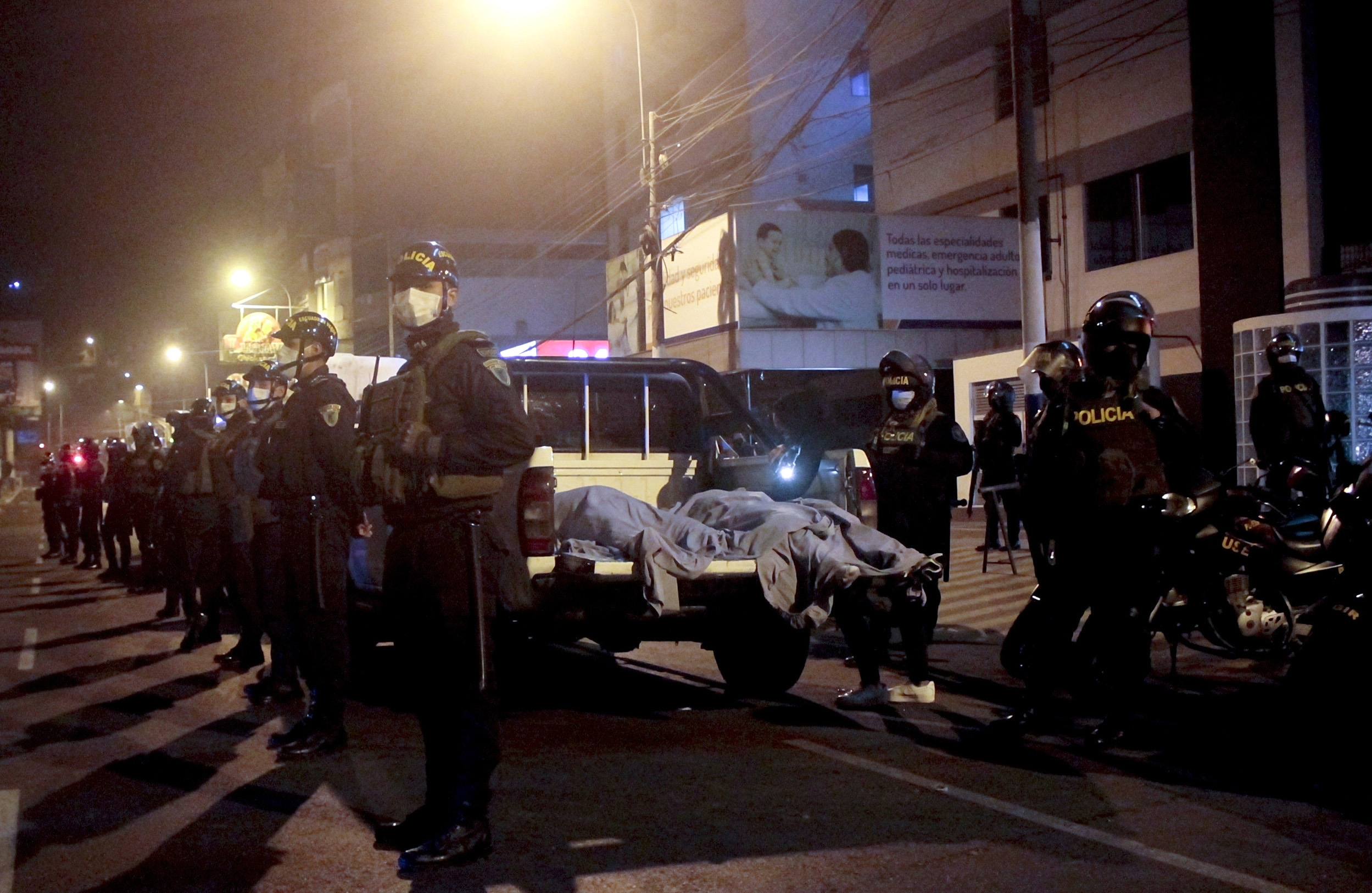 PHOTO: Police officers stand guard near two bodies outside of a disco in Lima, Peru, Aug. 23, 2020.